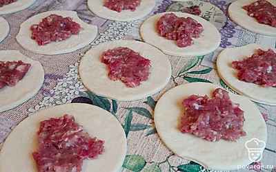 Тесто раскатываем в пласт толщиной примерно 1 сантиметр. Вырезаем из пласта кружочки. Выкладываем на каждый кружок фарш. 