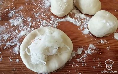 Шарик теста разминаем и выкладываем на него квашеную капусту.