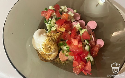 В миску поместите огурец, помидор, сосиску, сметану и ваши любимые специи. 