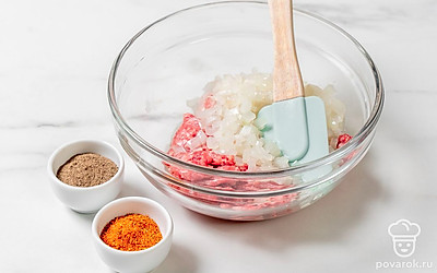 Нарежьте мелко лук, слегка обжарьте на 1 столовую ложку подсолнечного масла. Смешайте лук с фаршем, добавьте оставшуюся соль, приправы для мяса и перец, хорошо перемешайте. 