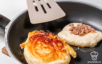 В центр каждого кружка положите чайной ложкой немного начинки, полейте ее небольшим количеством сырого теста и переверните. Жарьте беляши еще примерно 2 минуты, пока они полностью не прожарятся и не покроются золотистой корочкой. 