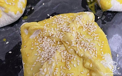 Пирожки выложить на противень, застеленный пекарской бумагой, смазать взбитом желтком, посыпать кунжутом. Отправить в духовку, разогретую до 180 градусов, на 15-20 минут.