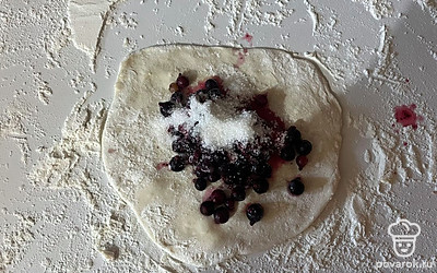 В центр теста выложите начинку из сахара и черной смородины.