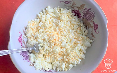 Приготовьте начинку. Измельчите вареные яйца удобным для вас способом: с помощью вилки, натрите на терке или просто мелко порежьте ножом.