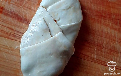 Выложите начинку и сформируйте пирожок, сложив тесто крест накрест. Сверху также обмажьте яйцом.