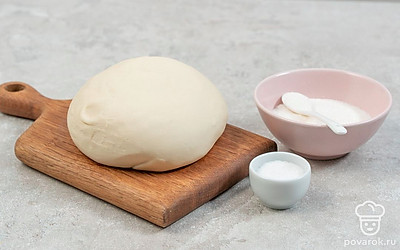 Замесите тесто. Смешайте муку, соль, соду, сахар и крахмал. Разведите в теплой воде дрожжи и через 10 минут влейте их в мучную смесь. Замесите тесто и оставьте в холодильнике на ночь.