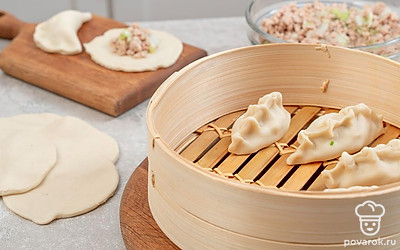 Приготовьте пирожки. Тесто разделите на 12 частей, раскатайте на лепешки. Положите в центр начинку. Края теста соберите сверху и защипните. Выложите в чашу пароварки, дайте постоять 20 минут. Включите пароварку, выставив таймер на полчаса.