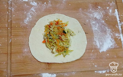 Готовое тесто посыпьте оставшимся крахмалом и вымешивайте его еще раз. Разделите тесто на 16 мучных кусочков, каждый из них раскатайте в небольшой кружок, в середину выложите овощную начинку и сформируйте пирожок, тщательно защипнув края теста. Проделайте аналогичные шаги со всем тестом и начинкой. Сформированные пирожки выложите на противень с пергаментом, промажьте их куриными желтками и отправьте в духовой шкаф, разогретый до 190 °С, выпекаться в течение 40 минут до румяной корочки.