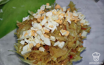 Когда капуста будет готова, добавьте мелконарезанные вареные яйца . Тщательно перемешайте.