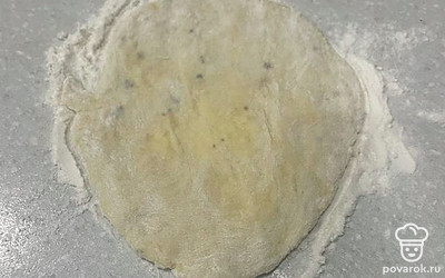 Возьмите 2 столовых ложки теста и руками раскатайте круглую лепешку.