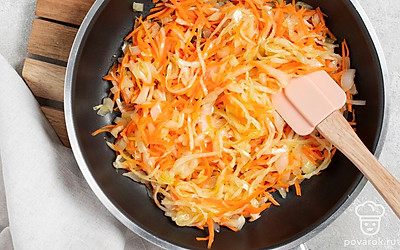 Сделайте начинку. Измельчите лук и морковь, выложите их на сковороду с маслом и готовьте до прозрачности. Отожмите квашеную капусту от лишней жидкости, выложите ее на сковородку и обжарьте до румяности.