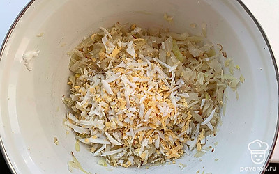 Переложить капусту в блюдо, добавить тертое на крупной тёрке яйцо. 