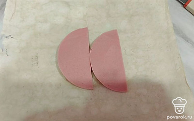 Выложить колбасу так, чтобы было удобно заворачивать.