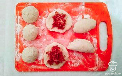 Готовое тесто разделите на небольшие шарики. Раскатайте каждый шарик в лепешечку, выложите в середину начинку и защемите края. Выложите пирожки на противень швом вниз и смажьте их желтком. Выпекайте в разогретой духовке при 180°С 30-35 минут до румяности.