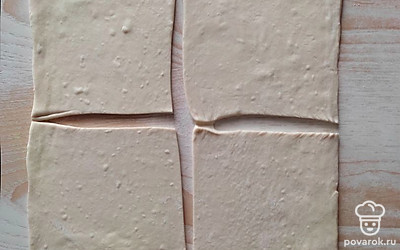 Разморозьте пласты слоеного теста. Раскатайте пласт в одном направлении. Разрежьте раскатанный пласт на 4 квадрата.