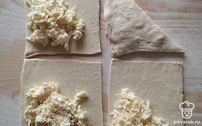 Для начинки натрите сыр на крупной терке. Оставьте немного тертого сыра для украшения слоек. Добавьте творог. От яйца отделите белок и добавьте к сырной массе, все хорошо перемешайте.