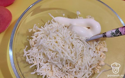 Желтки растереть вилкой в мелкую крошку, смешать с тертым сыром, чесноком и майонезом. 