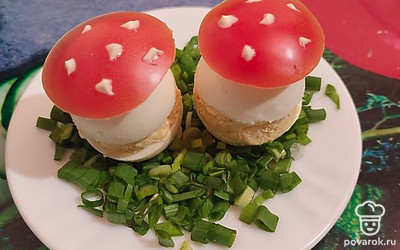 Подавать яйца на тарелке, усыпанной зеленым луком. Шляпки можно украсить точечками майонеза.