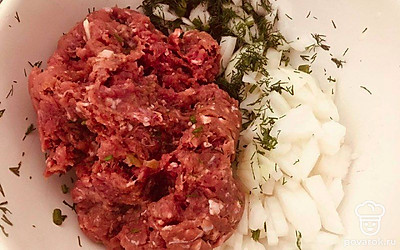 Мелко порубите лук и зелень, добавьте в фарш. Перемешайте его около 10 минут, чтобы структура была более воздушная.