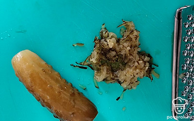 Натираем  на терке соленый огурец. Добавляем его к печени трески.