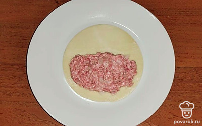 На заготовку в виде пласта теста выложите фарш. Края теста смажьте водой. 