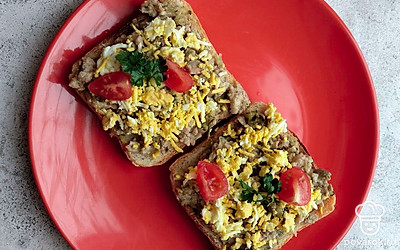 Выкладываем смесь на хрустящий тостер. Украшаем остатками яйца, зеленью и нарезанным помидором черри. Бутерброд готов. Приятного аппетита.