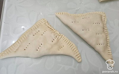 Сверните тесто, придайте треугольную форму. Защипните с помощью вилки края. Сделайте несколько проколов, чтобы во время жарки не образовывались пузыри. 