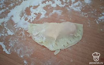 Сверните кружок вдвое и скрепите края вилкой.