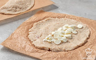 Положите на одну половину лепешки половину ломтиков моцареллы. Сверните пергамент, чтобы вторая половина лепешки накрыла сыр. Слегка прижмите половинки лепешки друг к другу. Сформируйте таким же образом второй чебурек.