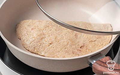 Поставьте сухую сковороду на слабый огонь, дождитесь, когда она разогреется. Выложите на сковороду чебуреки, аккуратно отделяя их от пергамента. Накройте сковороду крышкой.