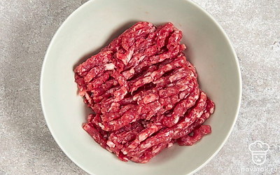 Нарежьте говядину небольшими кусочками. Пропустите ее через мясорубку, чтобы получился фарш.