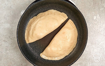 Разогрейте сухую сковороду без масла. Выложите на нее чебуреки и обжарьте их с каждой стороны до появления румяной корочки.