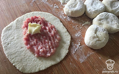 На доске, припыленной мукой раскатайте кусочки теста в круги, выложите на одну половинку фарш. Для сочности можно добавить кусочек сливочного масла.