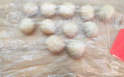 Отдохнувшее тесто раскатайте в жгут, нарежьте на порции. Скатайте шарики. Это заготовки для будущих чебуреков. Не забудбье накрывать заготовки пленкой или полотенцем.