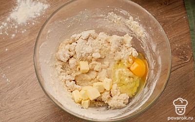 Добавьте яйцо, масло, соль, сахар и водку. Досыпьте оставшуюся муку и начните замешивать тесто.