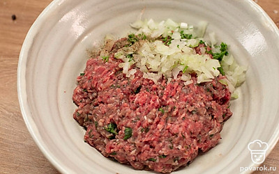 Приготовьте начинку: к фаршу добавьте лук, зелень, соль и перец. Хорошо перемешайте и влейте немного ледяной воды.