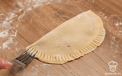 Тонко раскатайте каждый шарик, выложите по 1 ст. л. фарша. Распределив его, защипните края и прижмите их зубцами вилки.