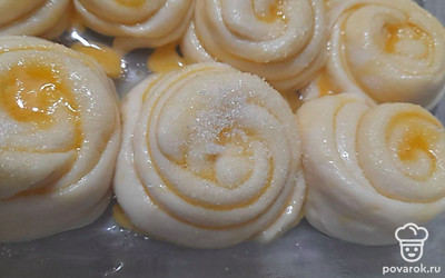 Смажьте булочки желтком и посыпьте оставшимся сахаром. Поставьте их в духовку. Выпекайте 25 минут при 180 градусах.