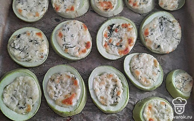 На запеченный кабачок выложите смесь из сыра, чеснока и майонеза. Отправьте в духовку на 5 минут.