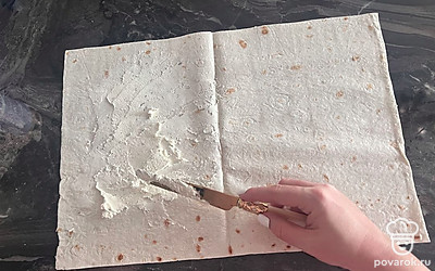 Разворачиваем лаваш. Намазываем тонким слоем творожный сыр с зеленью.