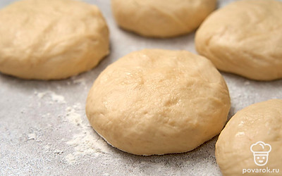 Снимите полотенце и слегка обомните поднявшиеся шарики сверху, чтобы будущие булочки получились с плоскими верхушками.