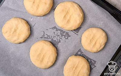 Переложите заготовки для булочек на противень с пергаментом на расстоянии друг от друга примерно в половину заготовки. Снова накройте их полотенцем и дайте постоять еще 15-20 минут.