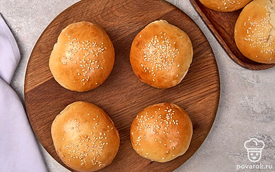 Выложите готовые булочки на сервировочное блюдо или доску, дайте им немного остыть перед приготовлением бургеров.