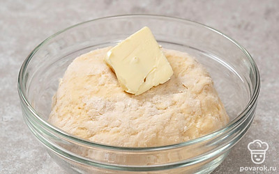 Частями введите муку, замесите густое однородное тесто. Добавьте мягкое сливочное масло. Вымешивайте тесто еще 10 минут.