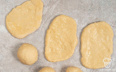 Смажьте рабочую поверхность растительным маслом. Обомните тесто и разделите его на 8 частей. Каждую часть раскатайте в продолговатую лепешку.