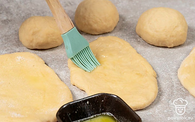 Растопите сливочное масло. Смажьте им тесто. Посыпьте сахаром, смешанным с ванильным сахаром. По длинной стороне сверните тесто в рулет и сложите пополам. Прижмите края.