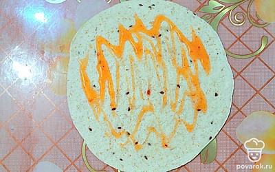 Поверхность тортильи смазать соусом чили.