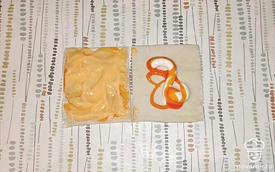 Разрежьте тесто на две равные половины. На каждую половину добавьте острый и чесночный соусы,равномерно распределите их.