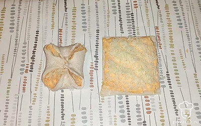 Затем щедро посыпьте тесто тертым сыром и сверните конвертиком с открытыми уголками, как показано на фото. Запекайте булочки в разогретой духовке при температуре 180-200 градусов до готовности. Приятного аппетита!