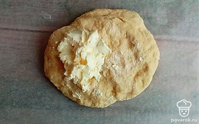 Выложить тесто, добавить сливочное масло. Тщательно вымесить, чтобы масло хорошо соединилось с тестом. 